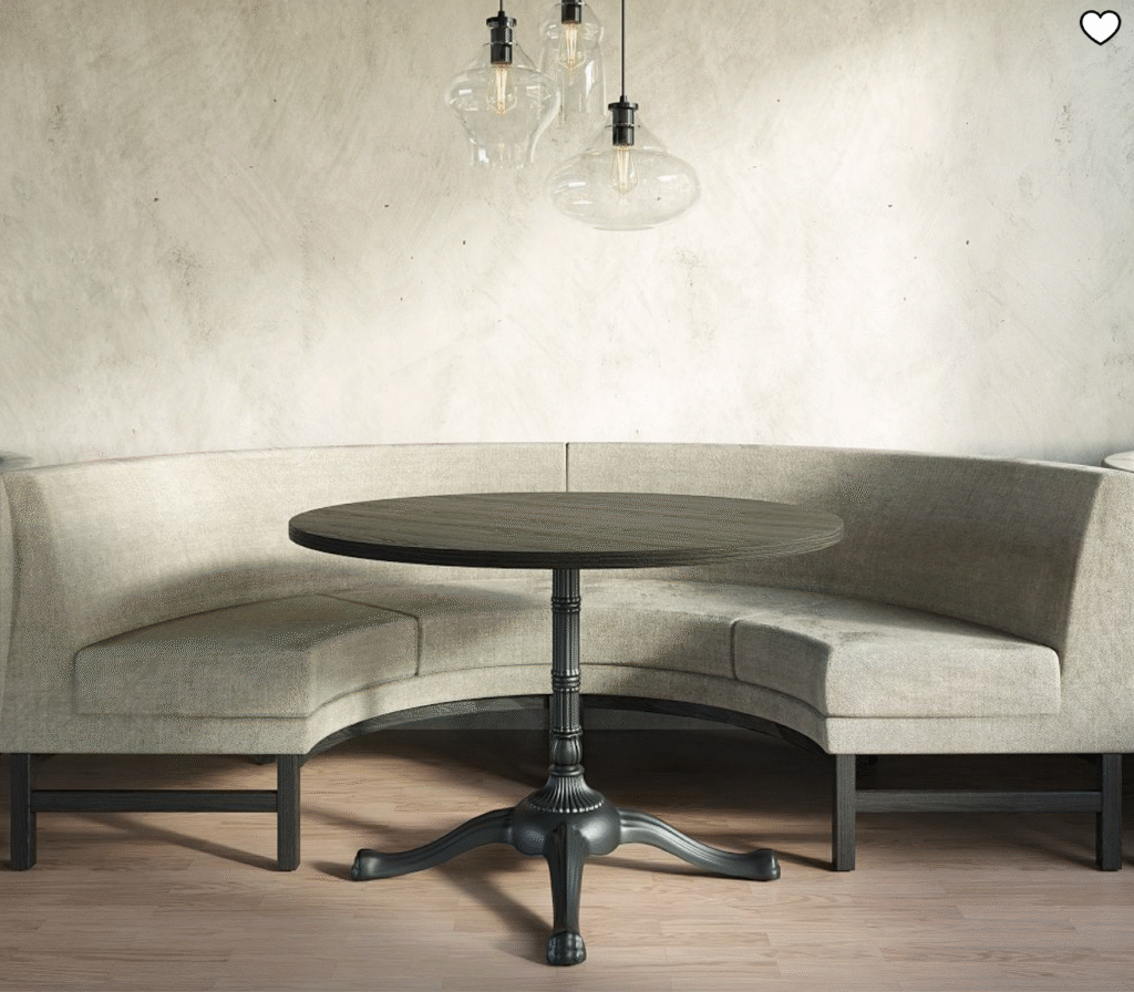 banquette seating in a corner dining space with a round wood table.